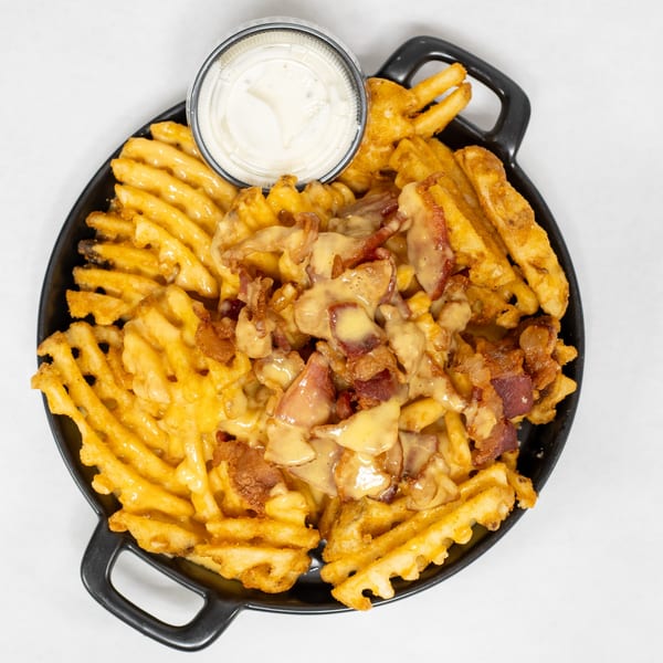 Cajun Crab & Shrimp Bar & Grill's waffle fries loaded with cheese sauce, bacon, and a side of ranch.