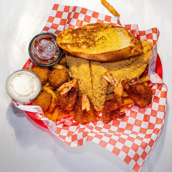 Cajun Crab & Shrimp Bar & Grill's fried seafood platter with fish, shrimp, hush puppies, fries, and garlic bread.