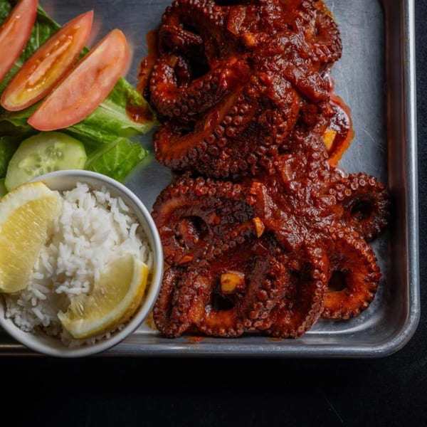 Cajun Crab & Shrimp Bar & Grill's spicy octopus with rice, lemon, and a side salad.