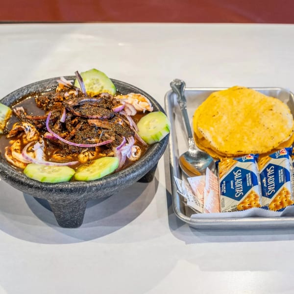 Cajun Crab & Shrimp Bar & Grill's seafood dish with shrimp, onions, and cucumbers, served with tortillas and crackers.