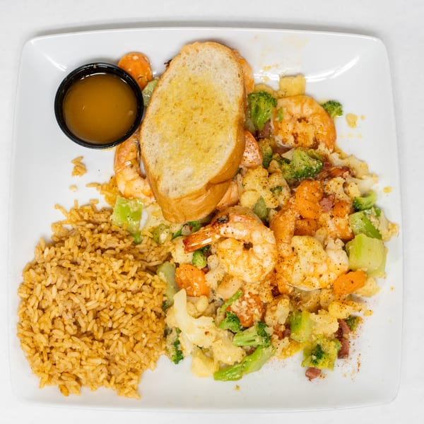 Cajun Crab & Shrimp Bar & Grill's shrimp and vegetable stir-fry with rice, garlic bread, and dipping sauce.