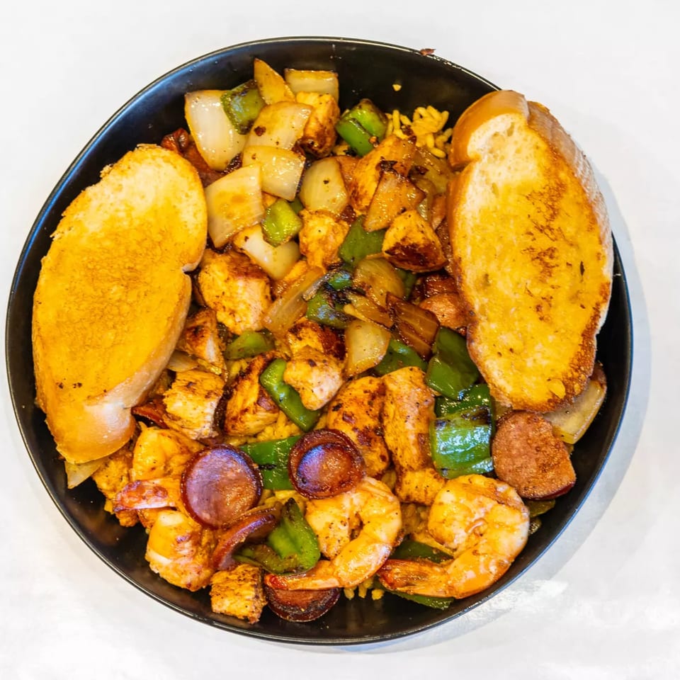Cajun Crab & Shrimp Bar & Grill's seafood dish with shrimp, sausage, chicken, peppers, onions, and garlic bread.