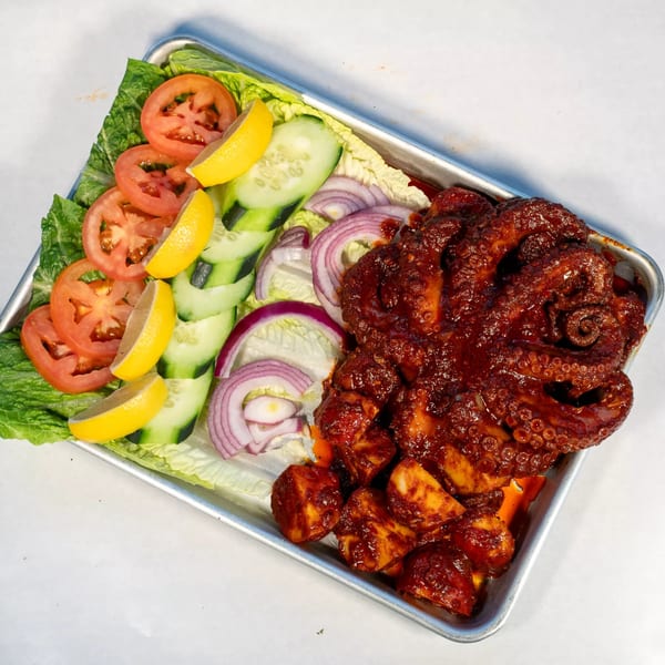 Cajun Crab & Shrimp Bar & Grill's grilled octopus with potatoes, salad, and lemon wedges.