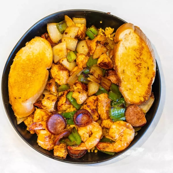 Cajun Crab & Shrimp Bar & Grill's seafood dish with shrimp, sausage, chicken, peppers, onions, and garlic bread.
